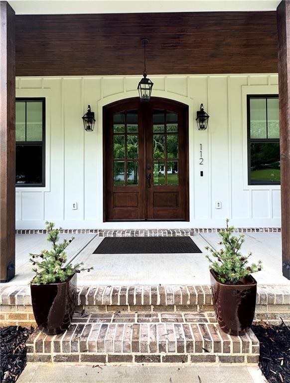 112 Three Oaks Dr SE, Calhoun, GA 30701 - entrance to property featuring a porch, board and batten siding, and french doors