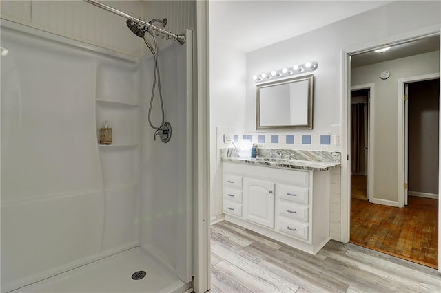 122 Vickery Dr, Fairburn, GA 30213 - full bathroom featuring vanity, a shower, wood finished floors, and tasteful backsplash