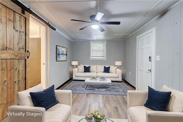 122 Vickery Dr, Fairburn, GA 30213 - living area featuring wood finished floors, ceiling fan, a barn door, and baseboards