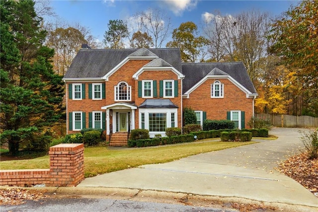 colonial-style house featuring a front lawn