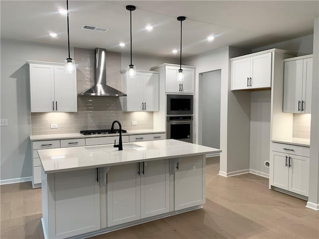 7206 Grand Reunion Dr, Hoschton, GA 30548 - kitchen with wall chimney exhaust hood, appliances with stainless steel finishes, decorative backsplash, white cabinetry, and an island with sink