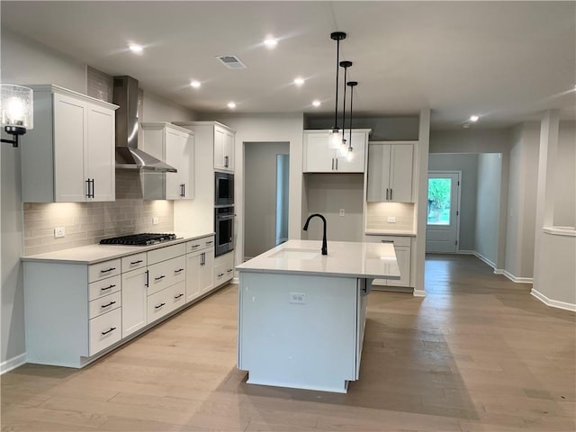 7206 Grand Reunion Dr, Hoschton, GA 30548 - kitchen with wall chimney exhaust hood, black oven, tasteful backsplash, stainless steel gas cooktop, and light wood-type flooring