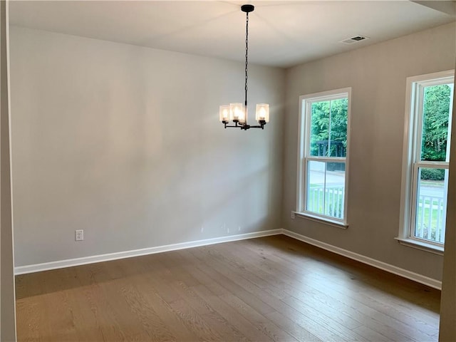 7206 Grand Reunion Dr, Hoschton, GA 30548 - empty room with dark wood-style floors, a chandelier, and plenty of natural light