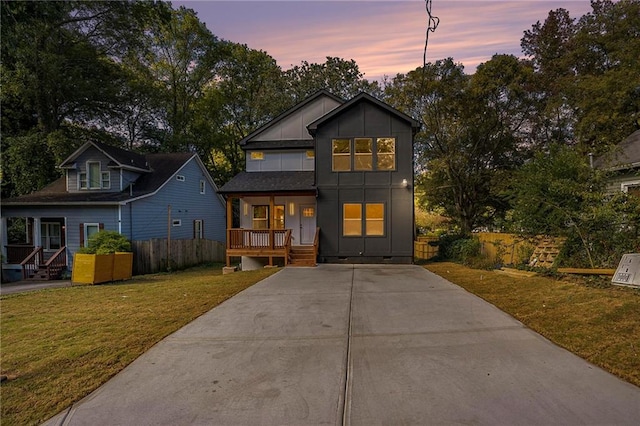 view of front of property with covered porch and a lawn