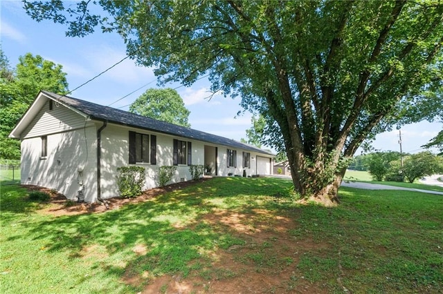 single story home with a garage and a front lawn