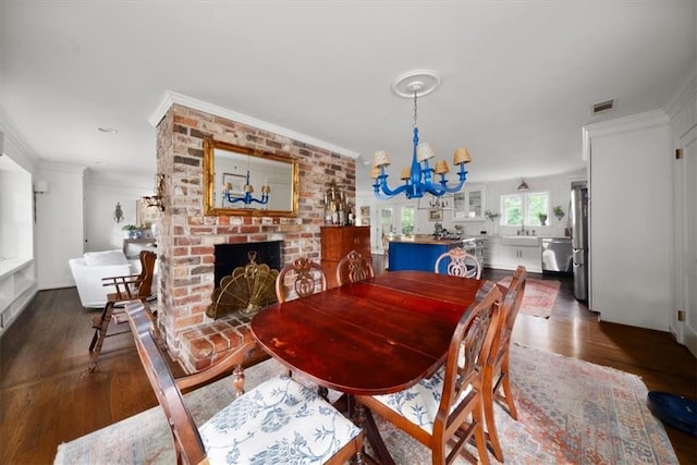 302 Chinquapin Dr SW, Marietta, GA 30064 - dining room with a chandelier, crown molding, dark wood-style floors, and a fireplace