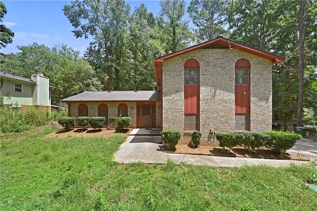 split level home featuring brick siding and a front yard