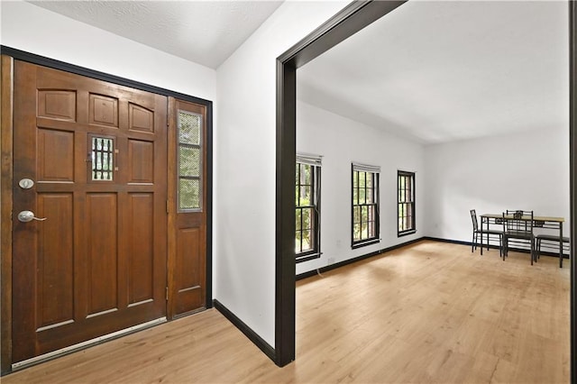 foyer entrance featuring light wood-style flooring and baseboards