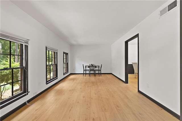 spare room featuring light wood-style floors, baseboards, and visible vents