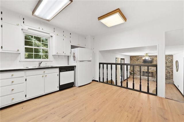 kitchen with light wood-style flooring, backsplash, white cabinets, a sink, and white appliances