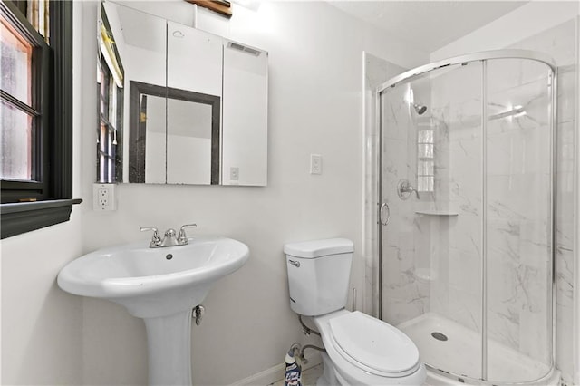 bathroom featuring baseboards, a shower stall, and toilet