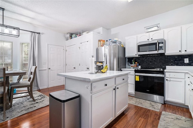 kitchen with white cabinets, appliances with stainless steel finishes, and dark wood-type flooring