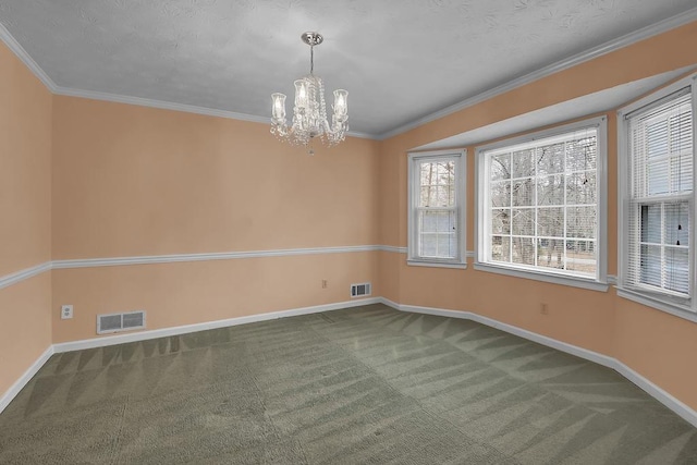 carpeted spare room featuring ornamental molding and a chandelier