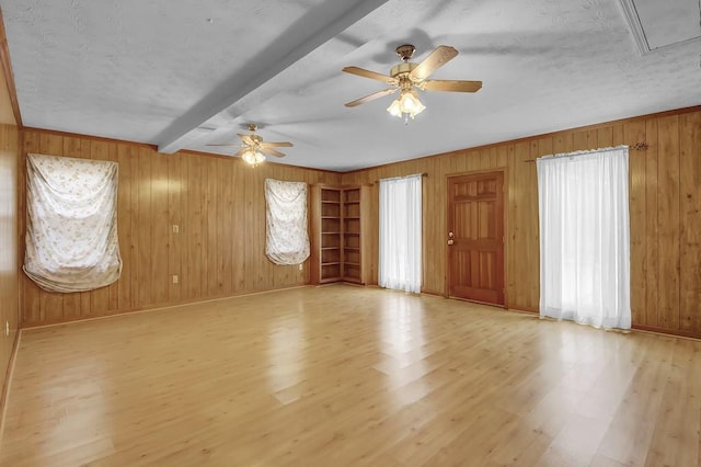 interior space featuring beamed ceiling, light hardwood / wood-style floors, and wood walls