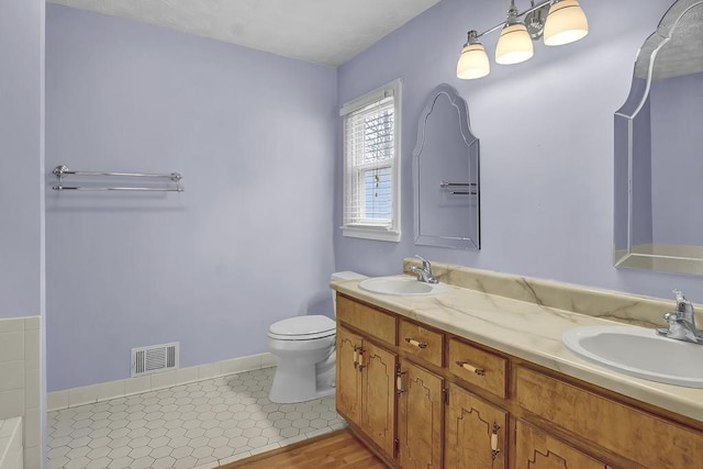 bathroom with vanity, tile patterned flooring, and toilet