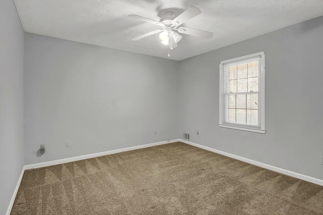 empty room with ceiling fan, carpet flooring, and a textured ceiling