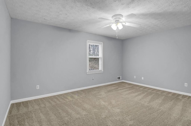 empty room featuring a textured ceiling, ceiling fan, and carpet