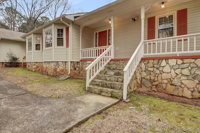 view of exterior entry featuring covered porch