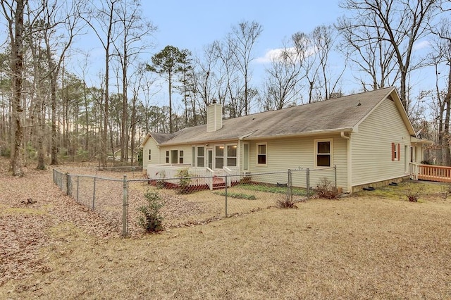 back of property with a wooden deck and a lawn