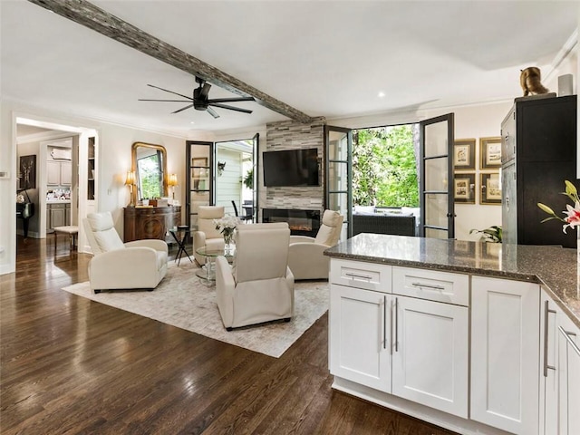 living room featuring ceiling fan, dark hardwood / wood-style flooring, a fireplace, and crown molding