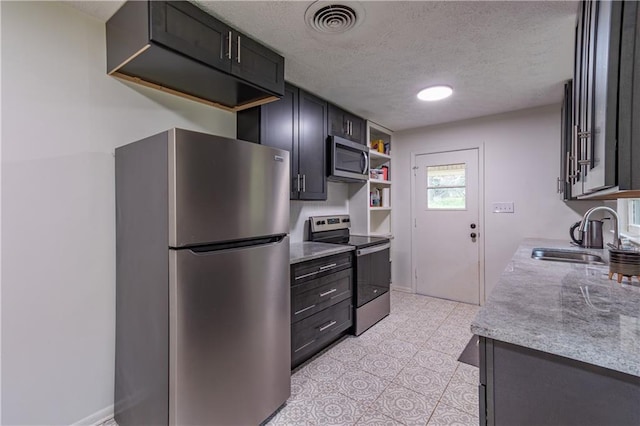 kitchen featuring stainless steel appliances, a textured ceiling, and sink