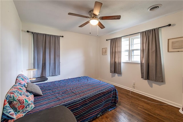 bedroom with dark hardwood / wood-style flooring and ceiling fan