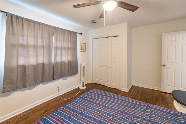 unfurnished bedroom with dark hardwood / wood-style flooring, ceiling fan, and a closet