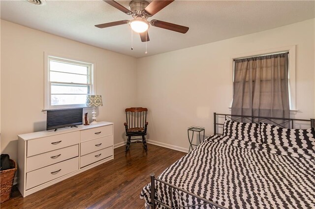 bedroom with dark hardwood / wood-style flooring and ceiling fan