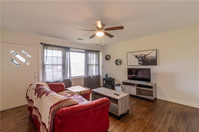 living room featuring dark wood-type flooring and ceiling fan