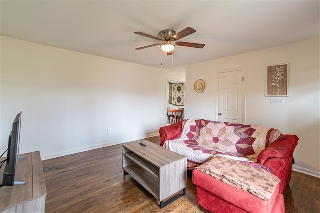 living room featuring dark wood-type flooring and ceiling fan