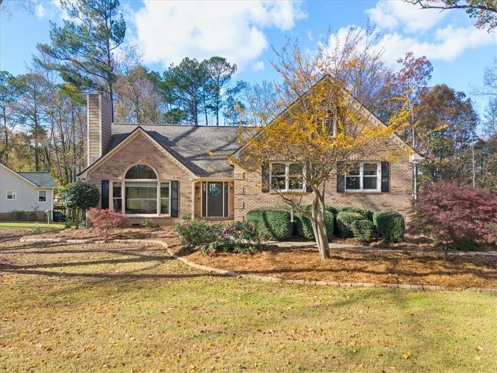 single story home featuring a front lawn