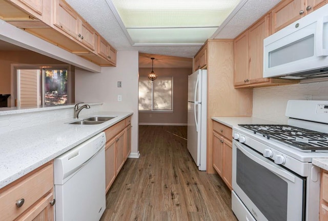 kitchen featuring white appliances, sink, decorative backsplash, decorative light fixtures, and light hardwood / wood-style floors