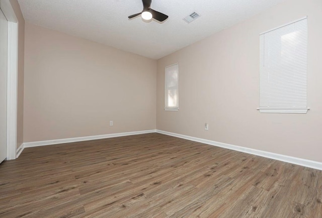 empty room with hardwood / wood-style floors and ceiling fan