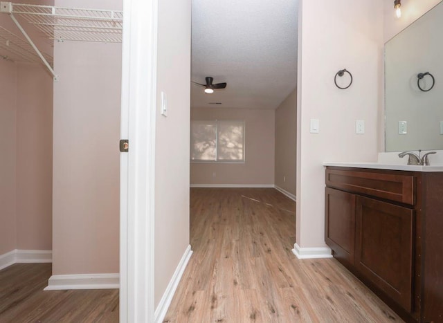 bathroom featuring ceiling fan, wood-type flooring, and vanity