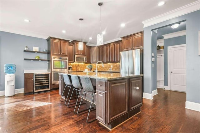 229 Primstone Way, Mcdonough, GA 30253 - kitchen featuring beverage cooler, stainless steel appliances, open shelves, a kitchen island with sink, and a breakfast bar
