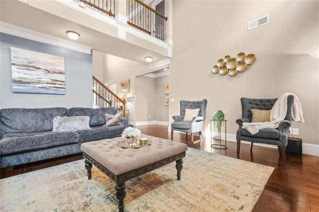 229 Primstone Way, Mcdonough, GA 30253 - living area with stairs, baseboards, dark wood-style flooring, a towering ceiling, and crown molding