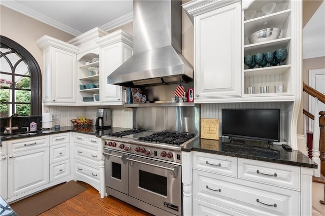 8643 Ellard Dr, Alpharetta, GA 30022 - kitchen with open shelves, range with two ovens, wall chimney range hood, crown molding, and white cabinets
