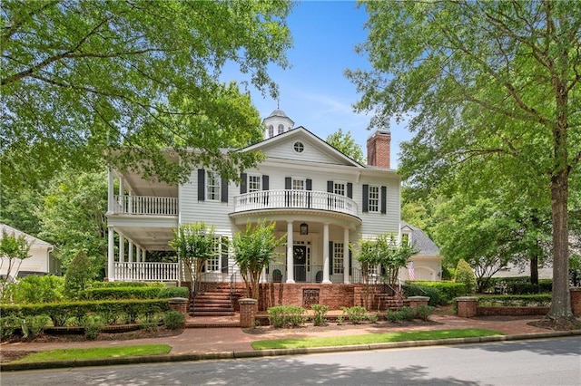 8643 Ellard Dr, Alpharetta, GA 30022 - greek revival house featuring a balcony, a porch, stairway, and a chimney