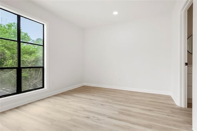 empty room featuring light wood-style flooring, baseboards, and recessed lighting