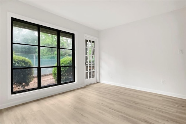 empty room featuring light wood-type flooring and baseboards