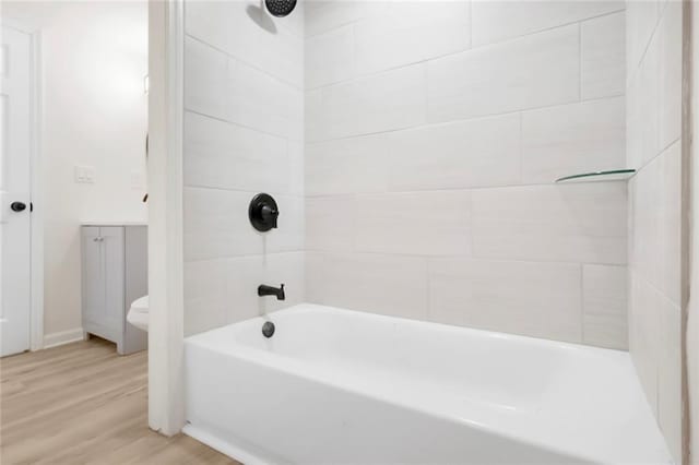 full bath featuring wood finished floors and bathtub / shower combination