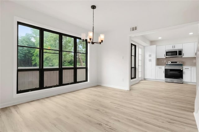 unfurnished dining area with a chandelier, baseboards, light wood-style flooring, and recessed lighting