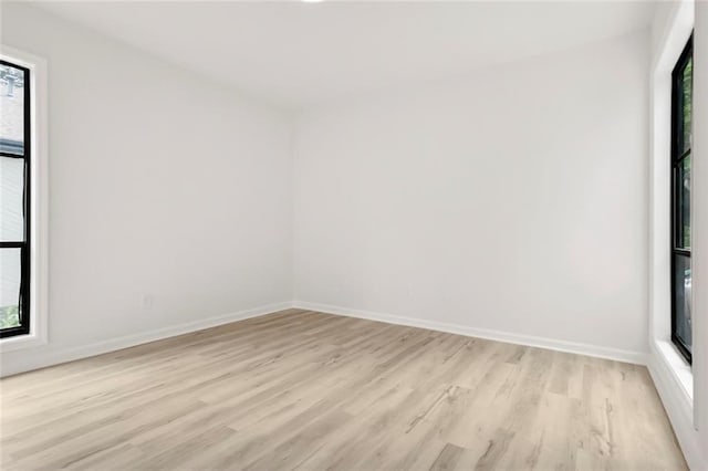 empty room with light wood finished floors and baseboards
