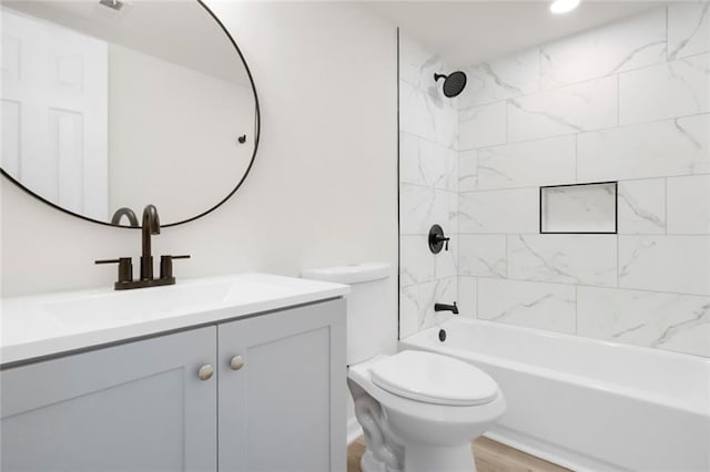 bathroom featuring toilet, vanity, shower / bath combination, wood finished floors, and recessed lighting