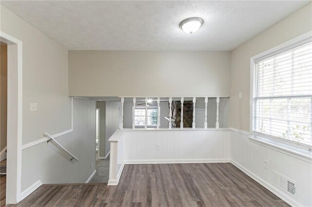 unfurnished room featuring a textured ceiling and dark wood-type flooring