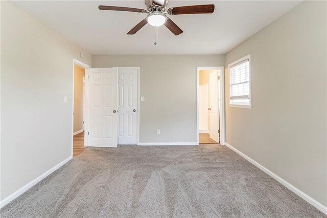 unfurnished bedroom with connected bathroom, ceiling fan, a closet, and light colored carpet