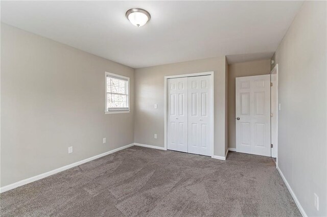 unfurnished bedroom featuring dark colored carpet and a closet