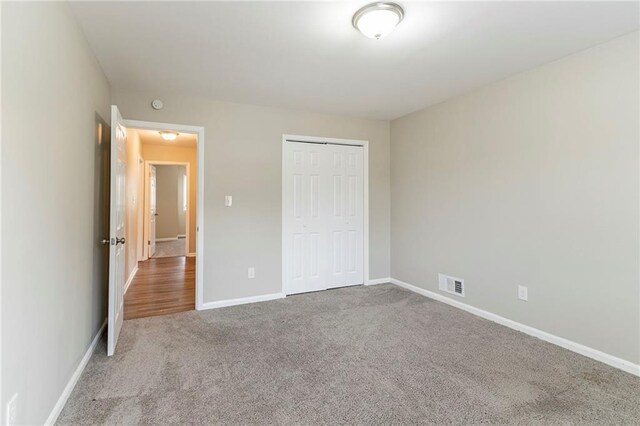 unfurnished bedroom featuring carpet flooring and a closet