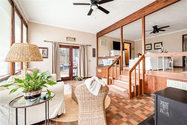 living area with a ceiling fan, ornamental molding, brick floor, stairs, and french doors