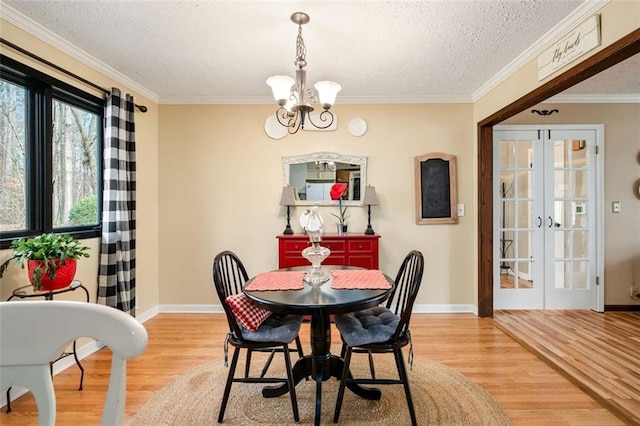 dining space with a textured ceiling, a notable chandelier, and wood finished floors